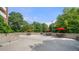 Outdoor patio with multiple bistro table sets under vibrant red umbrellas surrounded by lush trees at 375 Ralph Mcgill Ne Blvd # 707, Atlanta, GA 30312