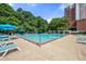 Community pool with lounge chairs, umbrellas, and shade from trees at 375 Ralph Mcgill Ne Blvd # 707, Atlanta, GA 30312