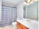Bathroom features a white vanity, framed mirror, and shower with stylish blue patterned curtain at 5765 Woodstone Dr, Cumming, GA 30028