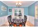 Formal dining room with chandelier, wainscoting, and view to the outdoor scenery at 5765 Woodstone Dr, Cumming, GA 30028