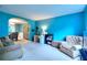 Bright living room with blue walls, neutral carpet, leading to a dining area with elegant furniture at 5765 Woodstone Dr, Cumming, GA 30028
