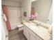 Well-lit bathroom featuring a granite countertop, a bathtub, and a pink shower curtain, complete with wood-look flooring at 6011 Pine Bluff Pl, Conyers, GA 30013