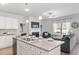 Bright kitchen island with granite countertops, white cabinets, and a view into the living room at 6011 Pine Bluff Pl, Conyers, GA 30013