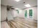 Finished basement area featuring wood flooring, walkout doors, and stairs to the upper level at 6133 Post Rd, Douglasville, GA 30135