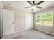 Bedroom features a ceiling fan, closet and backyard view at 6133 Post Rd, Douglasville, GA 30135