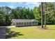 Well-kept front yard and ranch-style home showcasing a covered porch and a blend of natural surroundings at 6133 Post Rd, Douglasville, GA 30135