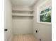 Laundry room with window, tiled floor and shelving at 6133 Post Rd, Douglasville, GA 30135