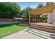 Spacious backyard with pergola-covered deck, lush lawn, and fire pit area for outdoor enjoyment at 700 Mill Creek Cv, Canton, GA 30115