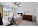 Bright bedroom features a ceiling fan, dresser, closet, and a window with natural light at 700 Mill Creek Cv, Canton, GA 30115