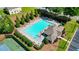 Aerial view of a community pool surrounded by lounge chairs, greenery, and a tennis court at 700 Mill Creek Cv, Canton, GA 30115