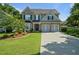 Charming two-story home with a well-manicured front lawn and a driveway leading to a two-car garage at 700 Mill Creek Cv, Canton, GA 30115