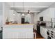Bright eat-in kitchen with white cabinets, hardwood floors, and modern lighting fixtures at 700 Mill Creek Cv, Canton, GA 30115