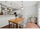 Eat-in kitchen with wood table, white chairs, hardwood floors, and modern lighting at 700 Mill Creek Cv, Canton, GA 30115