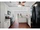 Bright kitchen with white cabinets, modern appliances, dark hardwood floors, and access to a breakfast area at 700 Mill Creek Cv, Canton, GA 30115