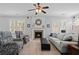 Cozy living room with a fireplace, comfortable seating, and natural light from shuttered windows at 700 Mill Creek Cv, Canton, GA 30115