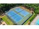 Aerial view of community tennis courts surrounded by lush greenery and trees for shade at 700 Mill Creek Cv, Canton, GA 30115