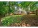 Expansive backyard featuring lush green grass, mature trees, and a wooden deck at 701 Robert Ln, Canton, GA 30114