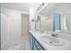 Double sink bathroom vanity with white tile floors and a large mirror at 701 Robert Ln, Canton, GA 30114