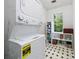 Efficient laundry room with stacked washer and dryer and storage shelves by the window at 701 Robert Ln, Canton, GA 30114