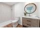 Modern bathroom featuring wood cabinets, tiled shower and a decorative round mirror at 2863 Landing Dr, Marietta, GA 30066