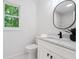 Stylish powder room featuring a modern vanity, oval mirror, and a window with natural light at 2863 Landing Dr, Marietta, GA 30066