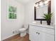 Well-lit bathroom with white vanity, decorative mirror, and hardwood floors at 2863 Landing Dr, Marietta, GA 30066