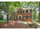 Traditional brick home featuring black shutters, mature trees and landscaping offering serene curb appeal at 2863 Landing Dr, Marietta, GA 30066