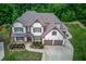 Aerial view of this spacious home featuring well-manicured lawn and a three car garage at 4241 Summer Breeze Way, Buford, GA 30518
