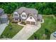 Aerial view of the spacious home featuring lush green lawn and a three car garage at 4241 Summer Breeze Way, Buford, GA 30518