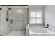 Bathroom featuring tiled walk in shower and separate tub under a bright window at 4241 Summer Breeze Way, Buford, GA 30518