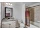 Bathroom with granite vanity, tile floors, framed mirror and shower over tub at 4241 Summer Breeze Way, Buford, GA 30518