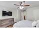 Bedroom features a ceiling fan, TV, and gray dresser at 4241 Summer Breeze Way, Buford, GA 30518