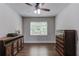 Neutral bedroom featuring a ceiling fan, natural light, and rustic wood accents at 4241 Summer Breeze Way, Buford, GA 30518