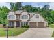 Charming two-story home boasts manicured landscaping, three-car garage and beautiful brick and siding exterior at 4241 Summer Breeze Way, Buford, GA 30518
