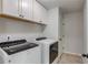 Laundry room features modern appliances and white cabinets at 4241 Summer Breeze Way, Buford, GA 30518