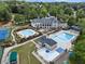 Aerial view showcasing the clubhouse, swimming pools, tennis courts, and lush landscaping of the community at 10135 High Falls Pointe, Johns Creek, GA 30022