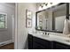Bathroom with a black vanity, quartz countertops, a large mirror, and decorative wall art at 10135 High Falls Pointe, Johns Creek, GA 30022