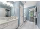 Charming bathroom featuring blue walls, a white vanity, and a large mirror with white tile floors at 10135 High Falls Pointe, Johns Creek, GA 30022