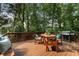 Outdoor deck with patio furniture and a grill, surrounded by lush greenery at 10135 High Falls Pointe, Johns Creek, GA 30022