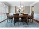 Elegant dining room with a large wooden table, seating for six, and stylish chandelier at 10135 High Falls Pointe, Johns Creek, GA 30022