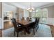 Spacious dining room with a wooden table and chairs, next to a large window with natural light at 10135 High Falls Pointe, Johns Creek, GA 30022