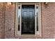 Close up of a classic black front door with sidelights, set in a brick facade at 10135 High Falls Pointe, Johns Creek, GA 30022