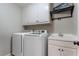 Bright laundry room includes modern appliances, a utility sink, and built-in storage cabinets at 10135 High Falls Pointe, Johns Creek, GA 30022