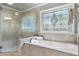 Main bathroom features a jetted tub beneath a stained glass window, and a glass enclosed shower at 10135 High Falls Pointe, Johns Creek, GA 30022