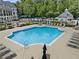 Relax by the outdoor pool, complete with lounge chairs and umbrellas, for a resort-style experience at 10135 High Falls Pointe, Johns Creek, GA 30022