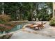 Relaxing pool area with stone trim, lounge chairs, and a private backyard at 10135 High Falls Pointe, Johns Creek, GA 30022
