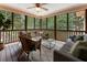 Screened porch with comfortable seating, ceiling fan, and a beautiful view of the surrounding landscape at 10135 High Falls Pointe, Johns Creek, GA 30022