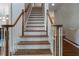 Elegant staircase with wooden handrails and white risers leading to the upper level at 10135 High Falls Pointe, Johns Creek, GA 30022