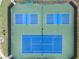 Top down view of tennis courts with blue surfaces surrounded by dark fences at 10135 High Falls Pointe, Johns Creek, GA 30022