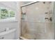 Tiled shower with glass enclosure and natural light from a window in an updated bathroom at 2786 Georgian Ter, Marietta, GA 30068